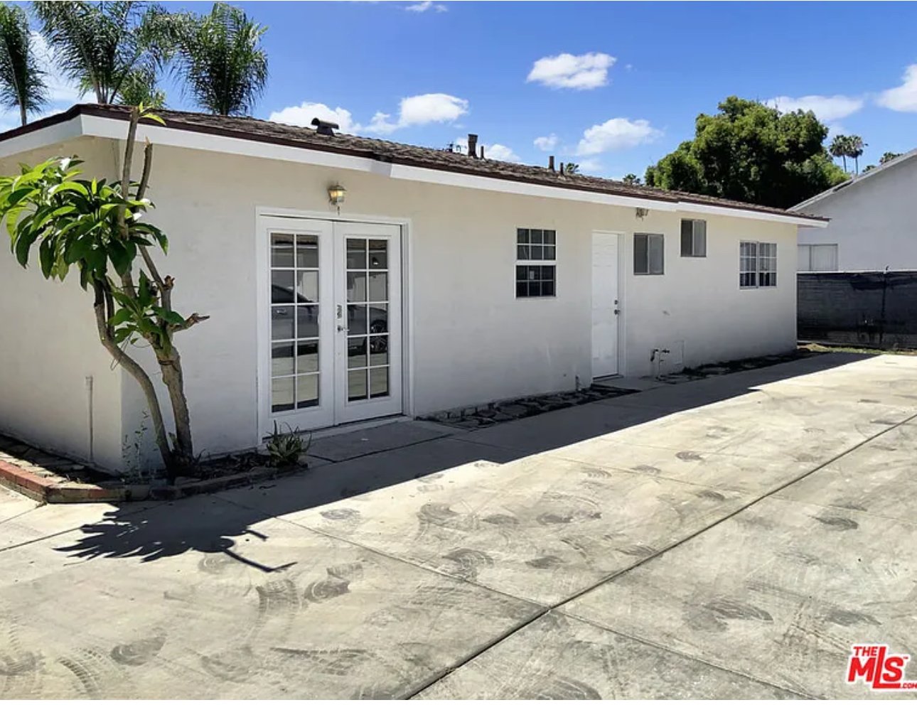 Single-story white house with one window, and a small tree in Pomona